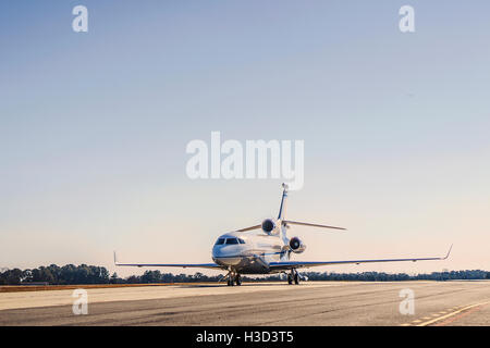 Private Jet on runway against clear sky Stock Photo