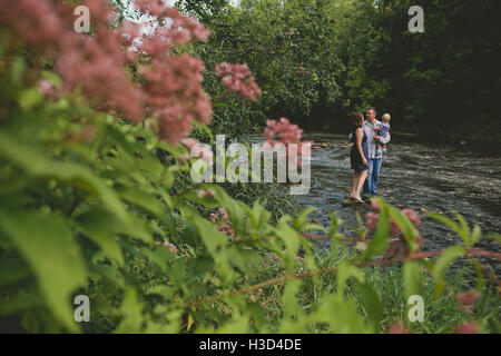Couple looking at each other while carrying son Stock Photo