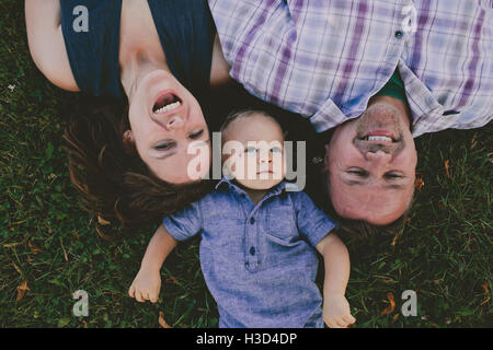 Overhead view of happy family relaxing on grassy field Stock Photo