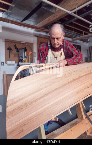 Senior man making boat in workshop Stock Photo