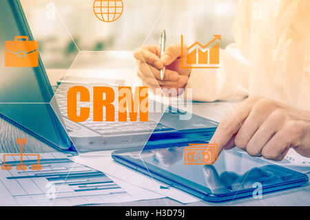 Business, technology, internet and networking concept. Businessman working on his laptop in the office, select the icon CRM. Customer Relationship Management. Stock Photo