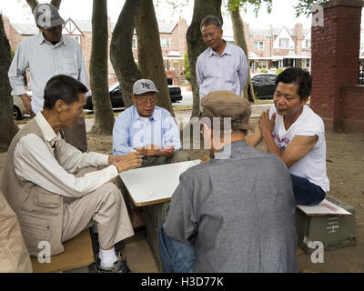 Chinese men playing cards in the park in Chinatown in the Sunset Park section of Brooklyn in NY, 2016. Stock Photo