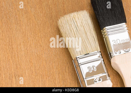 two paint brushes on wooden background closeup view Stock Photo
