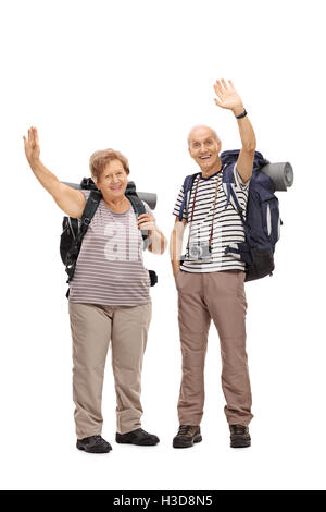 Full length portrait of two senior hikers waving at the camera isolated on white background Stock Photo