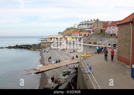 Sheringham, Norfolk, UK. September 24, 2016.  The promenade and beach at high tide with holidaymakers enjoying a September day a Stock Photo