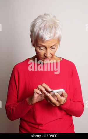 confused senior woman using smartphone Stock Photo