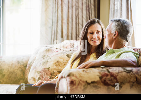 Smiling senior couple sitting on a sofa. Stock Photo
