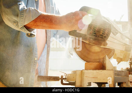 Senior man using a circular saw. Stock Photo