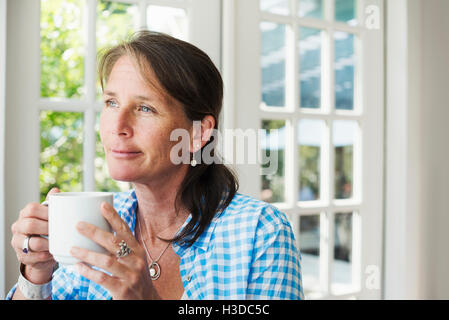 A woman having a cup of coffee. Stock Photo