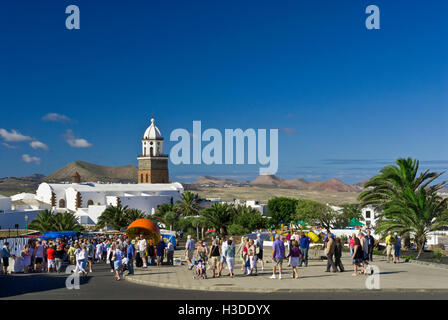 TEGUISE MARKET LANZAROTE Tourists visiting popular Sunday market day in Teguise old town with volcanoes behind Lanzarote Canary Islands Spain Stock Photo