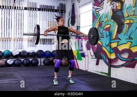 A female athlete trains in a crossfit gym. Stock Photo