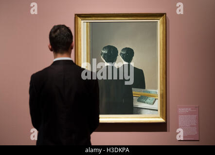 Hamburg, Germany. 5th Oct, 2016. A man looks at the piece Not to be Reproduced (Rene Magritte, 1937) at the Kunsthalle art gallery in Hamburg, Germany, 5 October 2016. The exhibition, which runs from 07 October 2016 until 22. January 2017, features more than 150 masterpieces of surrealism from four of the most significant European private collections of the 20th century. PHOTO: DANIEL REINHARDT/DPA/Alamy Live News Stock Photo