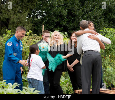 Washington DC, USA. 6th October, 2016. First Lady Michelle Obama  gets a hug from her husband, President Barack Obama after he makes a surprise appearance in the White House garden.  From  left to right, Kjell Lindgren, a NASA Astronaut and Elmo from Sesame Street also assisted the Michelle Obama as she participates in her last White House vegetable garden harvest . Credit:  Patsy Lynch/Alamy Live News Stock Photo