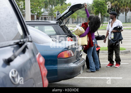 Weston, FL, USA. 6th Oct, 2016. fl-matthew-shelter-ta-3-ng : (left) Katongo Chama with her father, Sedelis Chama, get their stuff out of her car outside the Red Cross Disaster Shelter at Falcon Cove Middle School in Weston Thursday as the effects of Hurricane Matthew begin to be felt. They live in a mobile home in Davie and itÃ¢â‚¬â„¢s their frist hurricane, so they felt it was safer to ride out the storm at a shelter. Hurricane Matthew returned to Category 4 strength Thursday morning and could be producing ''extremely dangerous'' sustained winds of 145 mph by the time it approaches Sou Stock Photo