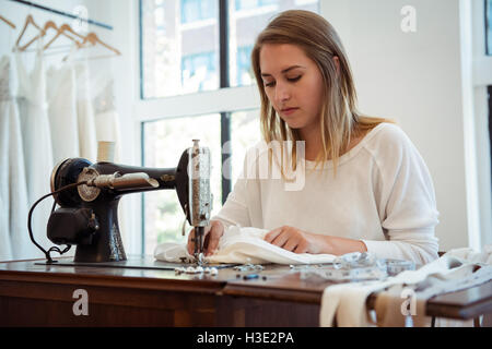 Female dressmaker sewing in the studio Stock Photo