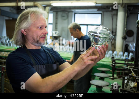 Glassblower examining glassware Stock Photo