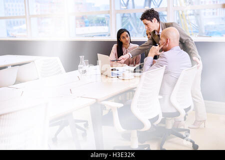mature female business professional supervising her employees in conference room Stock Photo