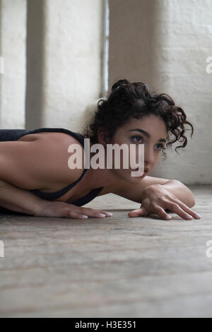 Scared young woman laying down on the floor looking away Stock Photo