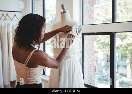 Fashion designer adjusting dress Stock Photo - Alamy