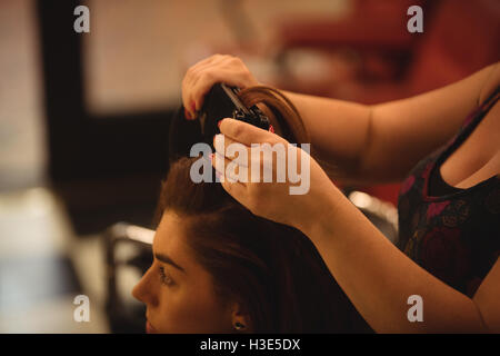 Woman is getting her hair straightened Stock Photo