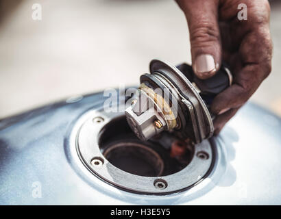 Mechanic opening a fuel tank of motor bike Stock Photo