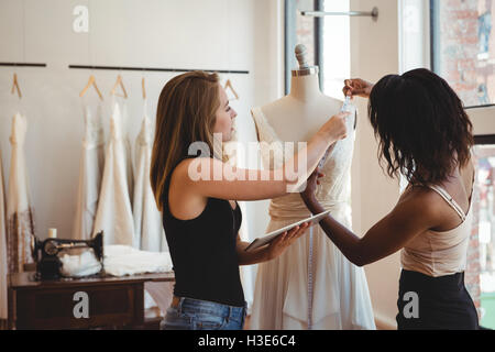 Female fashion designers working on a digital tablet Stock Photo