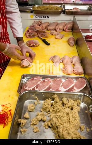 Mid section of butcher preparing a chicken and steak roll Stock Photo