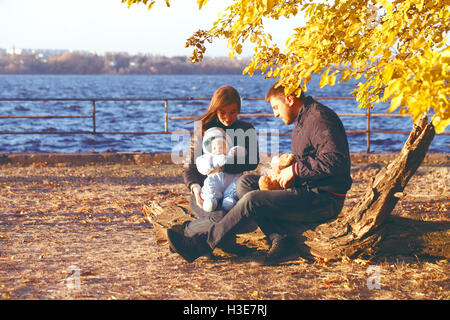 happy family walking outdoors, father, mother and cute baby Stock Photo