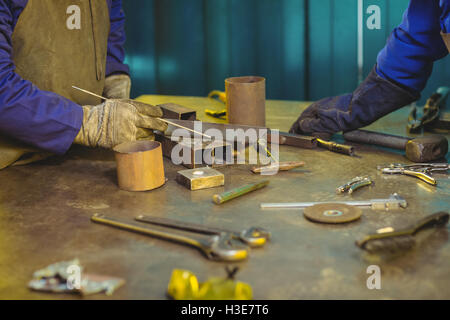 Mid-section of male and female welders working together Stock Photo