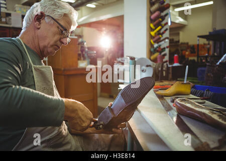 Shoemaker repairing a shoe Stock Photo
