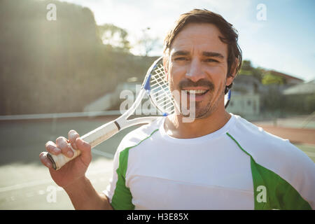 Portrait of happy man standing with a tennis racket Stock Photo