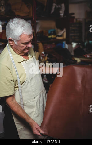 Shoemaker examining a piece of leather Stock Photo