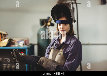 Portrait of female welder wearing glove Stock Photo