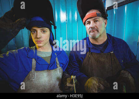 Portrait of male and female welder standing together Stock Photo