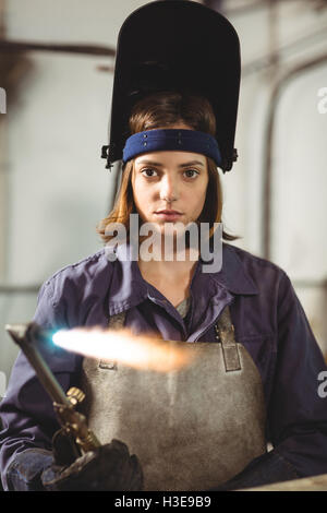 Female welder holding welding torch Stock Photo