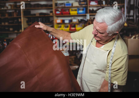 Shoemaker examining a piece of leather Stock Photo