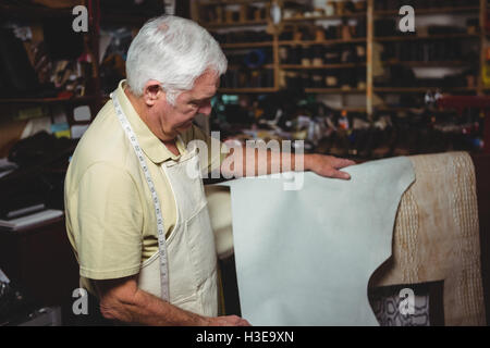 Shoemaker examining a piece of leather Stock Photo