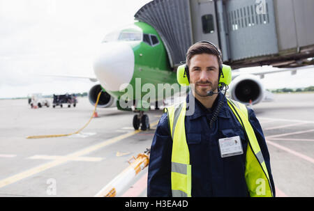 Portrait of airport ground crew standing on runway Stock Photo - Alamy