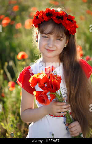 Portrait of a cute little girl in the meadow with poppies