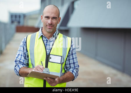 Portrait of construction worker writing on clipboard Stock Photo