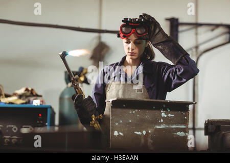 Female welder holding welding torch Stock Photo