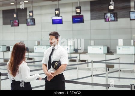 Pilot and flight attendant interacting with each other Stock Photo