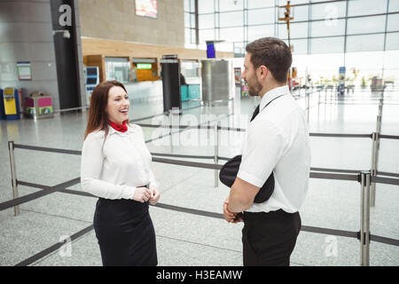 Pilot and flight attendant interacting with each other Stock Photo