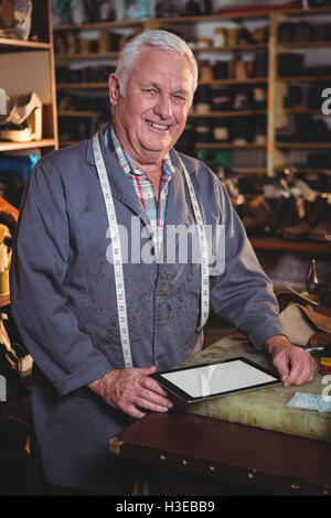 Portrait of shoemaker using digital tablet Stock Photo