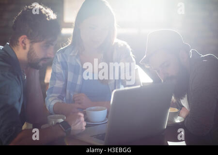 Friends using laptop at cafe Stock Photo