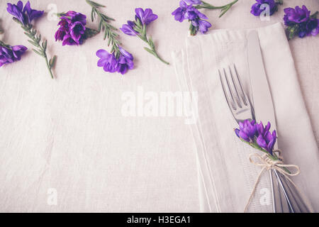 Purple flower table place setting on linen toning copy space background Stock Photo