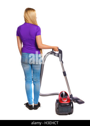 Rear view of a woman with a vacuum cleaner. She is busy cleaning. Rear view people collection. backside view of person. Isolated over white background. Long-haired blonde in the purple shirt holding a vacuum cleaner. Stock Photo