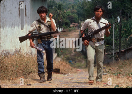 TENANCINGO,  EL SALVADOR, MARCH 1984: - Within the FPL Guerrilla's Zones of Control.  Two guerrilla fighters make their way through the abandoned streets of this contested town. Stock Photo