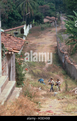 TENANCINGO,  EL SALVADOR, MARCH 1984: - Within the FPL Guerrilla's Zones of Control.  Two guerrilla fighters make their way through the abandoned streets of this contested town. Stock Photo