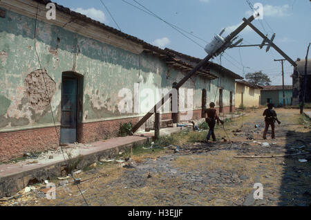 TENANCINGO,  EL SALVADOR, MARCH 1984: - Within the FPL Guerrilla's Zones of Control.  Guerrilla fighters walk down streets in the  ruined town of Tenancingo. Stock Photo